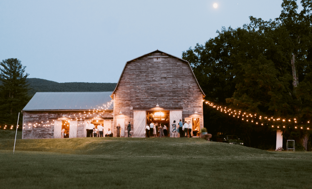 Guests gather at the barn to enjoy a beautiful wedding reception in the mountains.